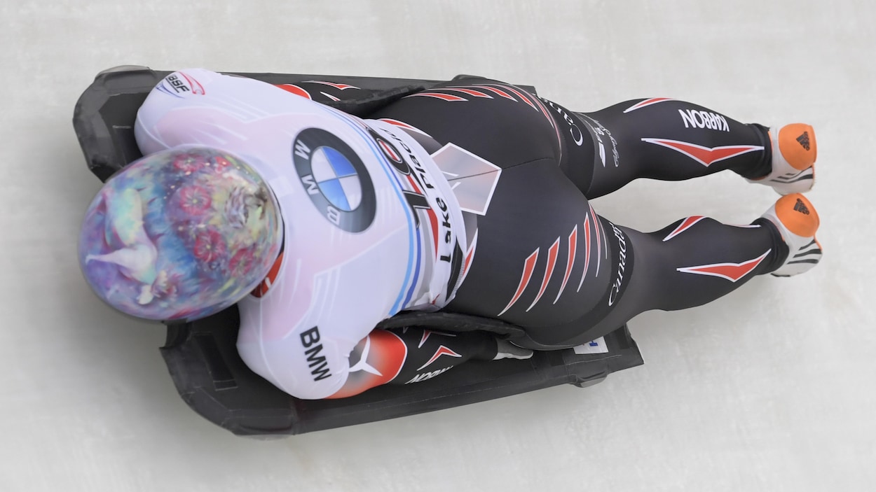 Elle est couchée sur son skeleton et glisse sur la piste.
