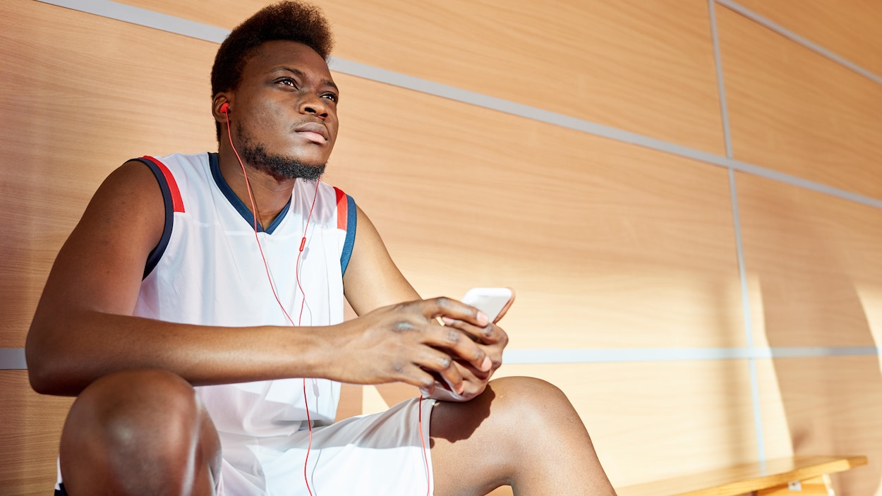 Un homme écoute de la musique dans un gymnase.