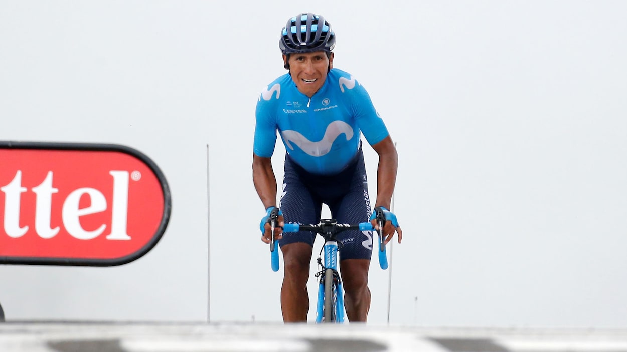 L'homme est en danseuse sur son vélo.