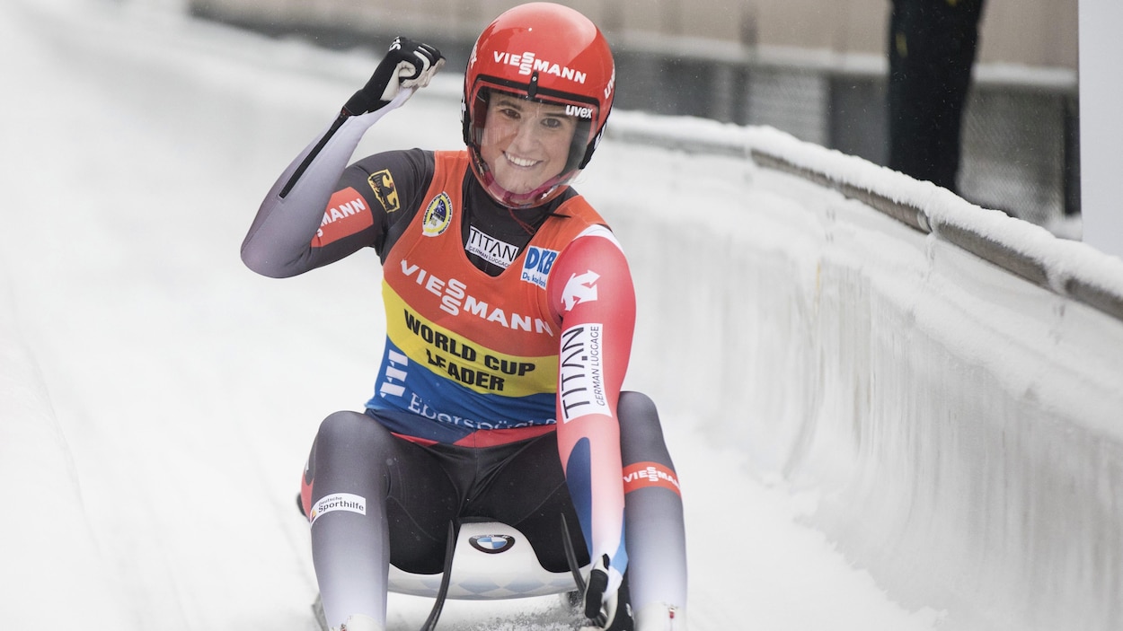 Elle sourit et lève le poing droit après une descente.