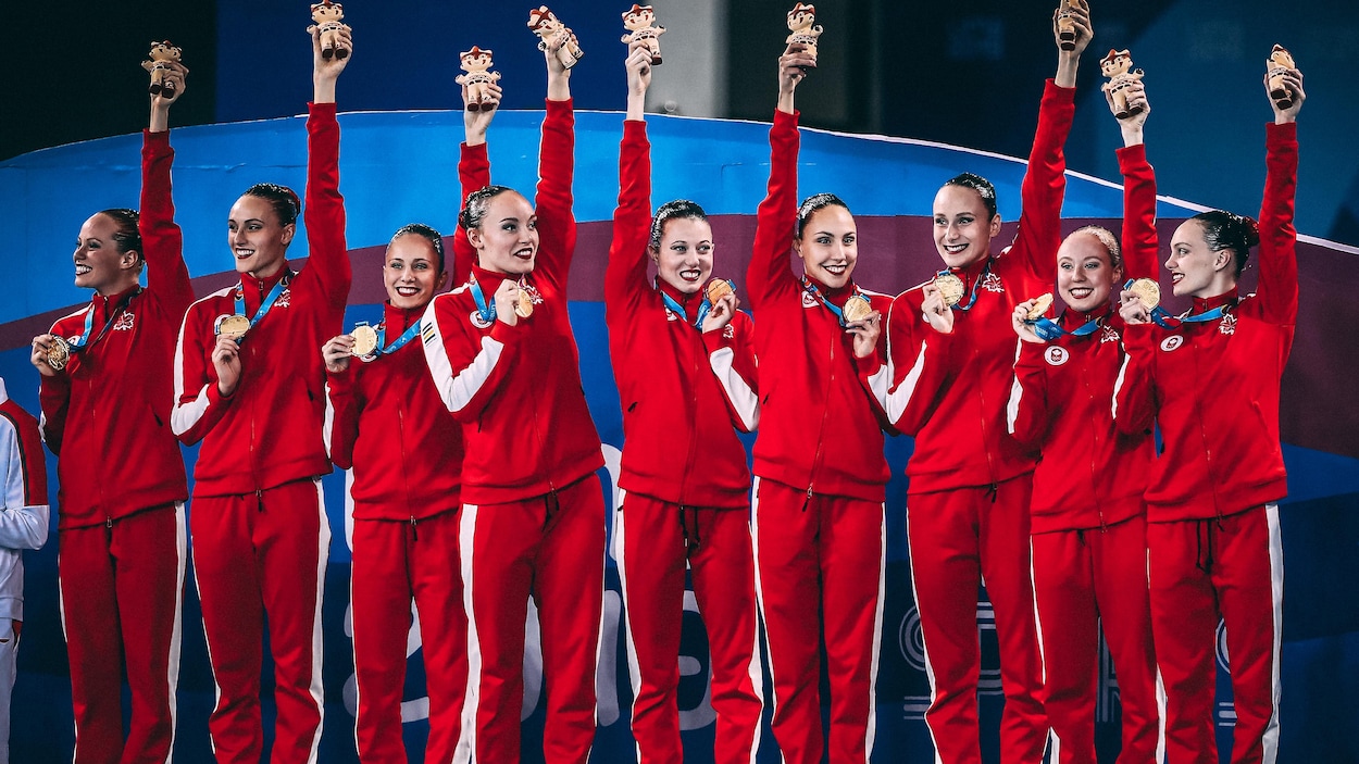 Elles tiennent leur médaille dans une main et le trophée en l'air dans l'autre. Elles tiennent leur médaille dans une main et le trophée en l'air dans l'autre.