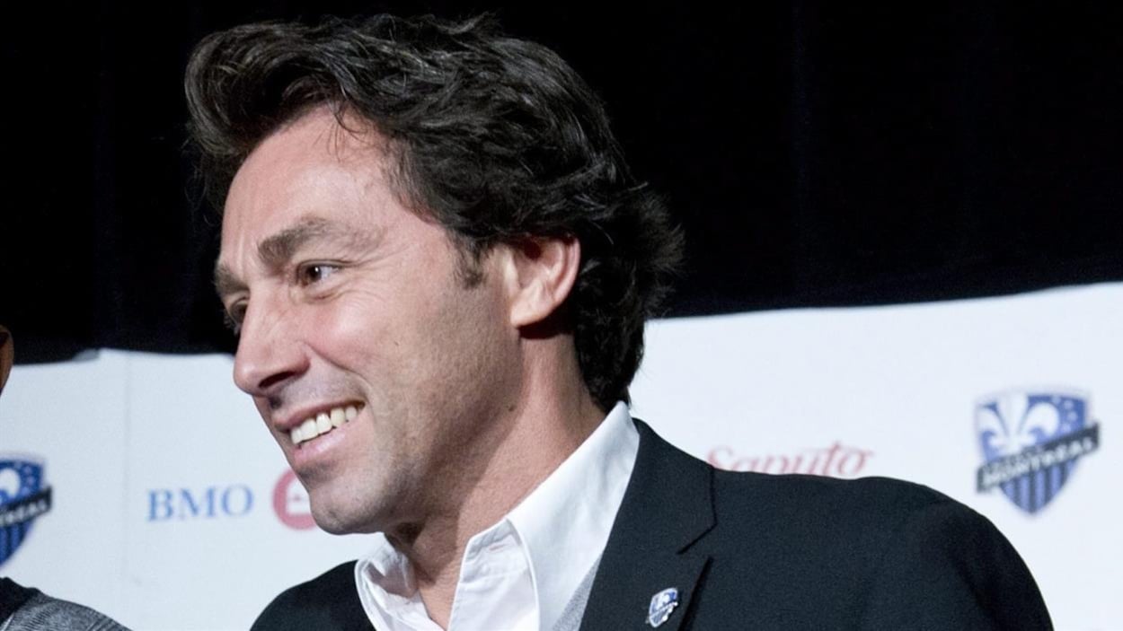 Il sourit pendant une conférence de presse.