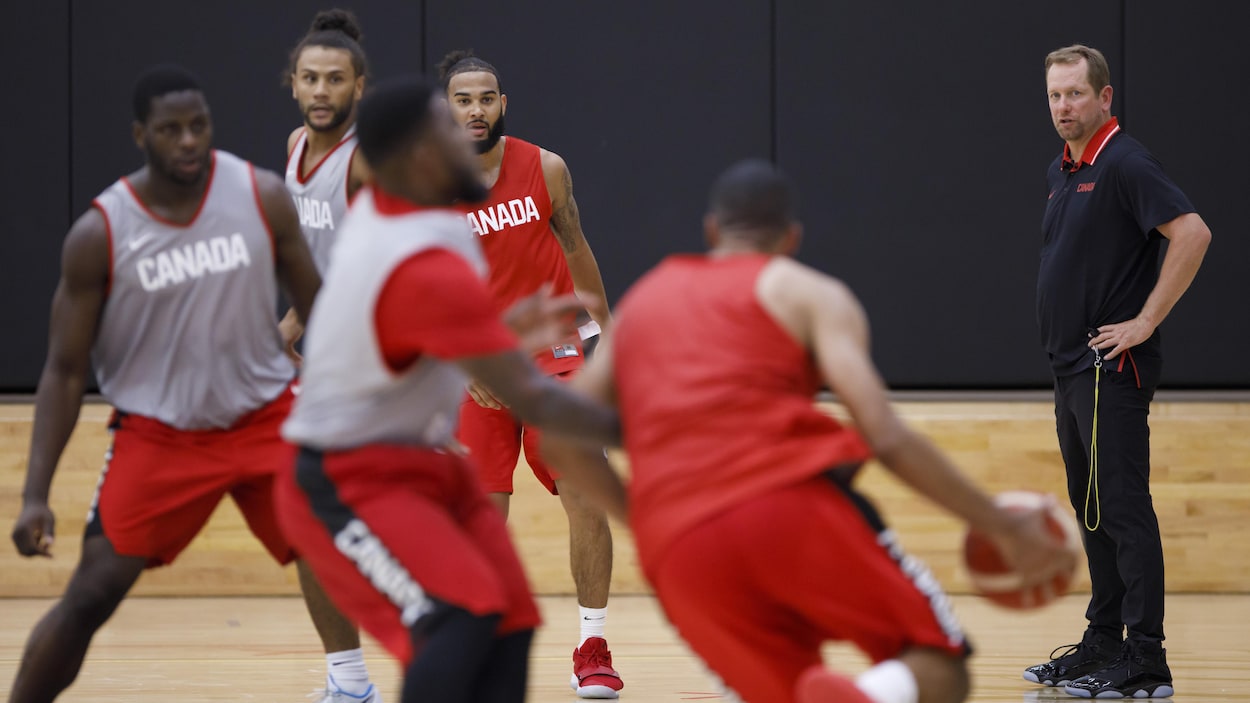 Il regarde ses joueurs en action.
