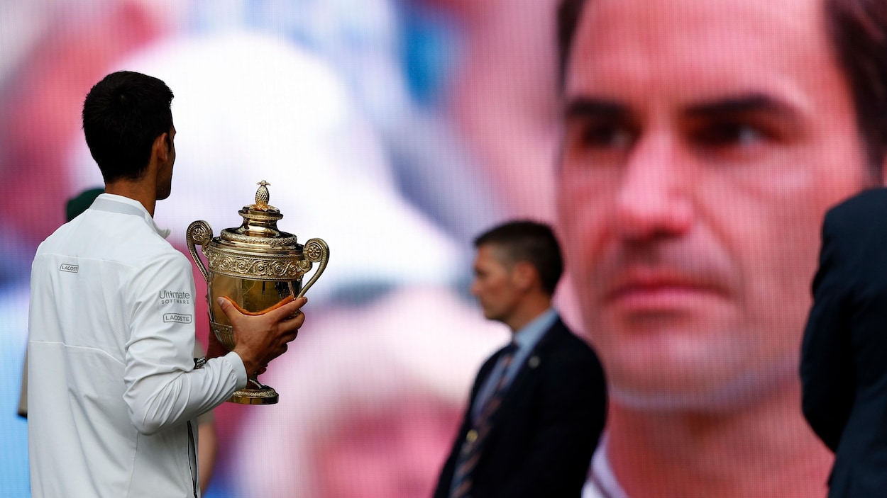 Le gagnant du tournoi de Wimbledon 2019, Novak Djokovic, devant un écran géant.
