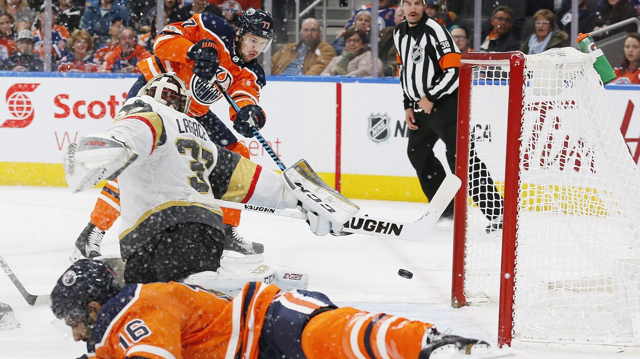 Oscar Klefbom pousse la rondelle derrière le gardien Maxime Lagacé des Golden Knights Oscar Klefbom pousse la rondelle derrière le gardien Maxime Lagacé des Golden Knights