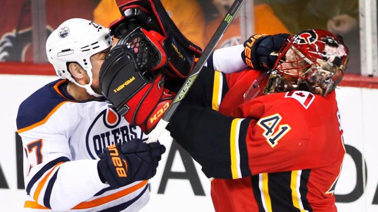 Altercation sur la glace entre deux joueurs : à g., des Oilers, et à d. des Flames