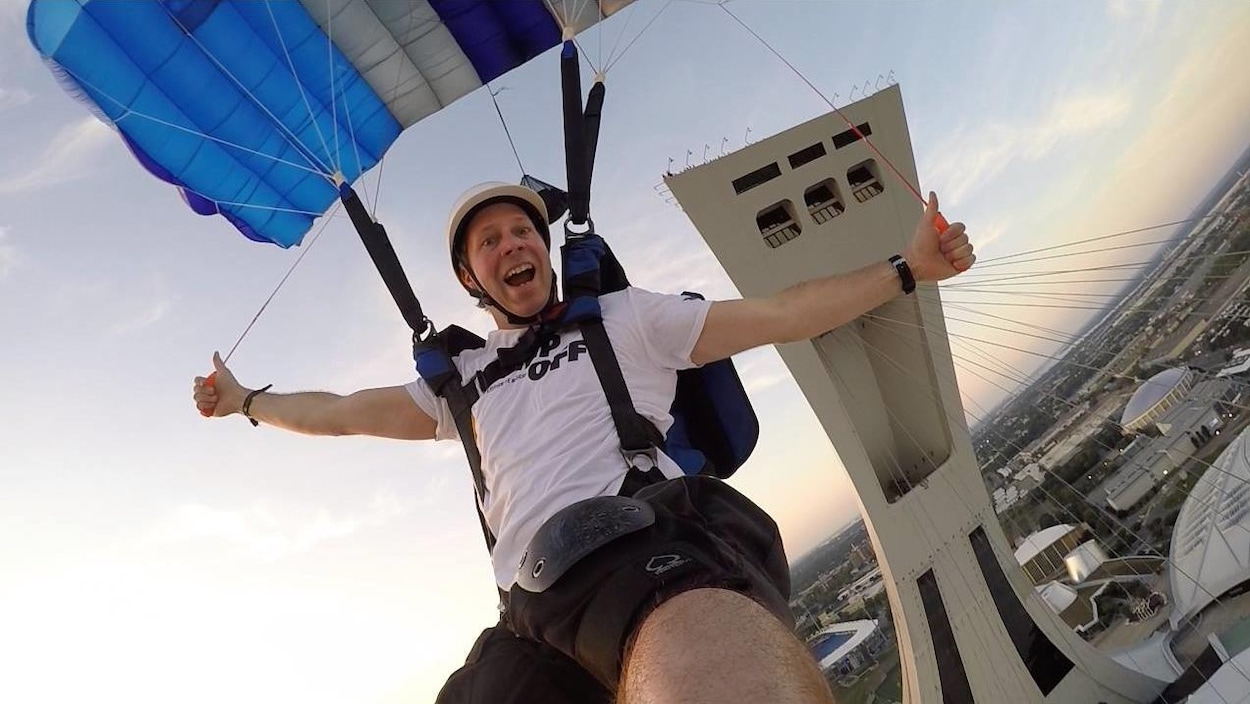 Il sourit tout en manipulant son parachute.