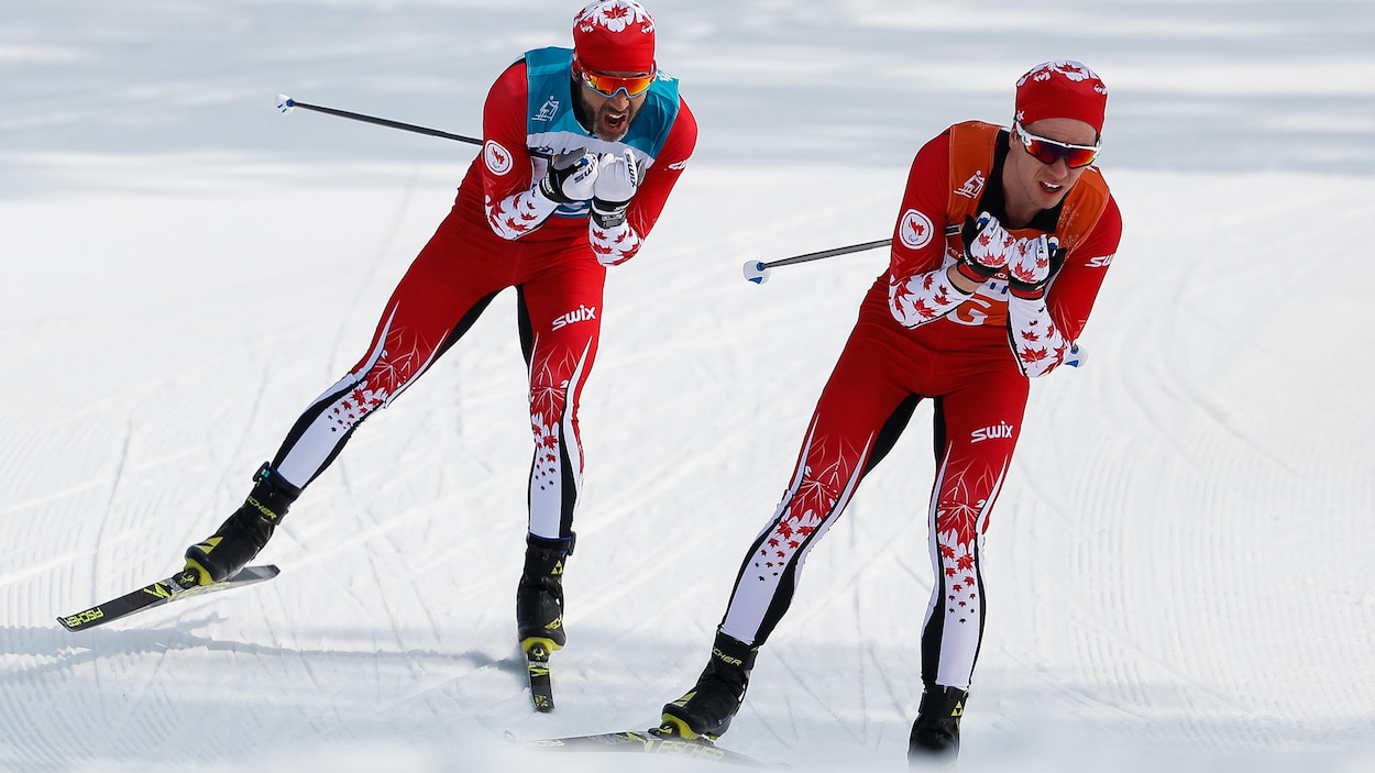 Deux skieurs se suivent de près.