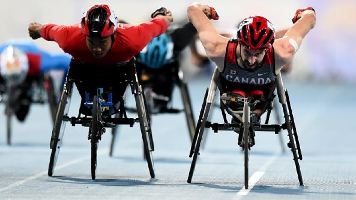 Deux adversaires sprintent côte à côte en fauteuil roulant.