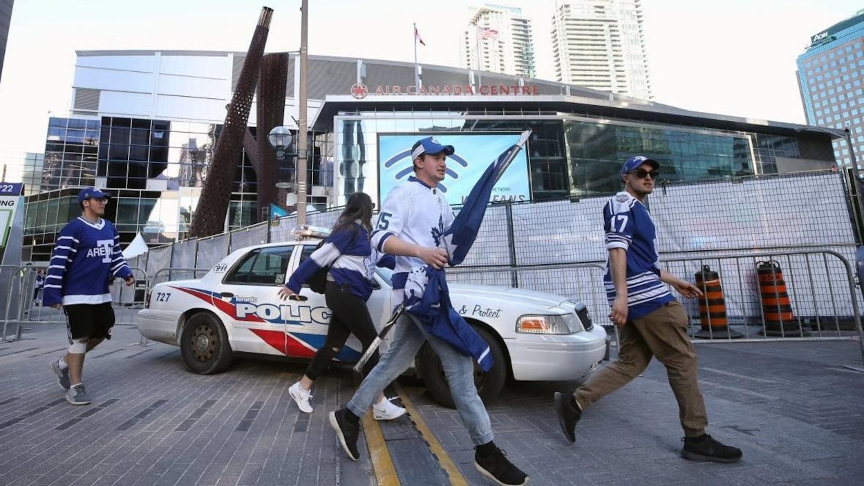 Des partisans des Maple Leafs devant une voiture de police. Des partisans des Maple Leafs devant une voiture de police.