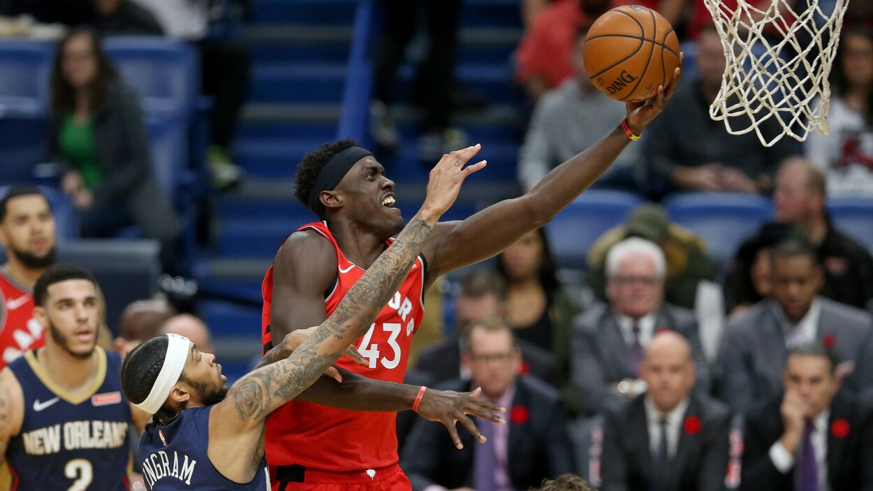 Un joueur de basketball porte le ballon au panier.