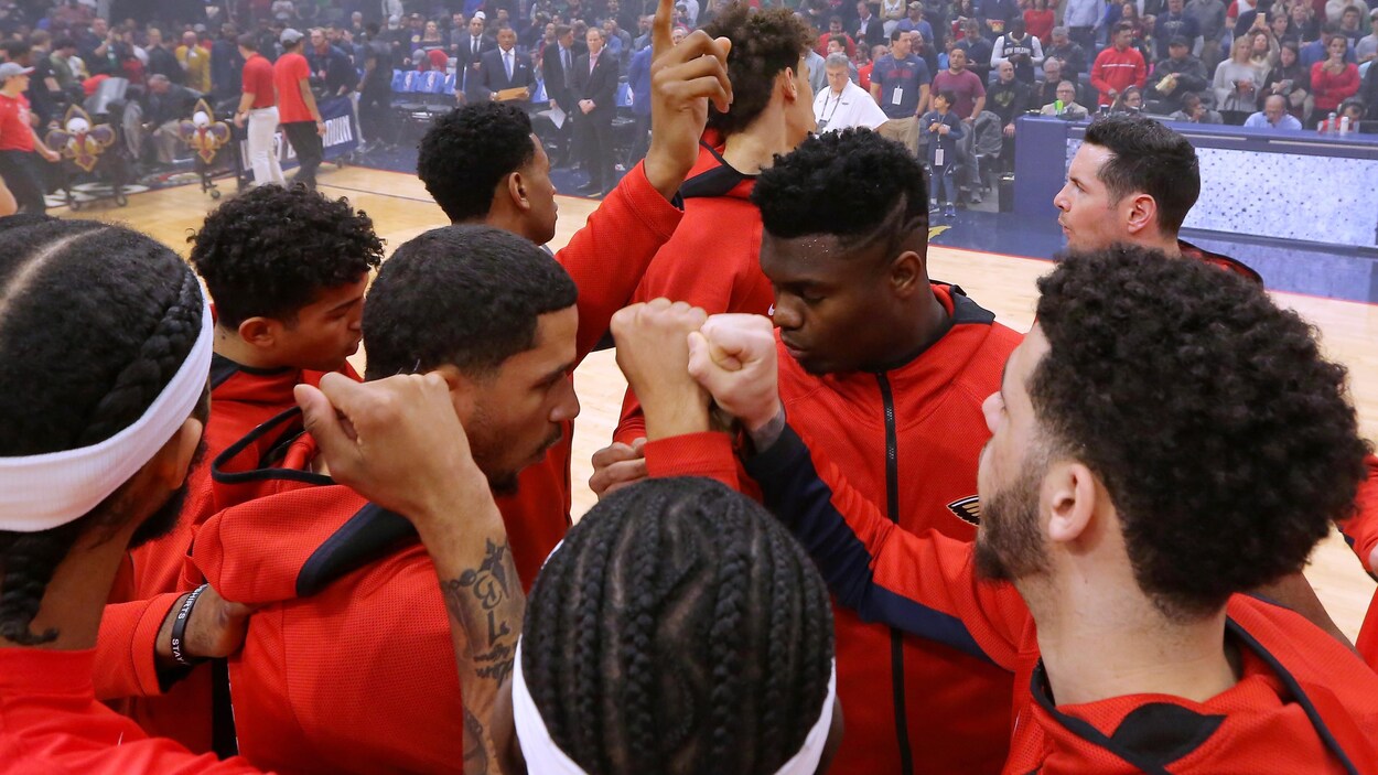 Une équipe se rassemble sur le court avant un match.