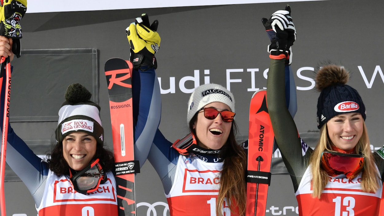 Trois skieuses sourient sur le podium.