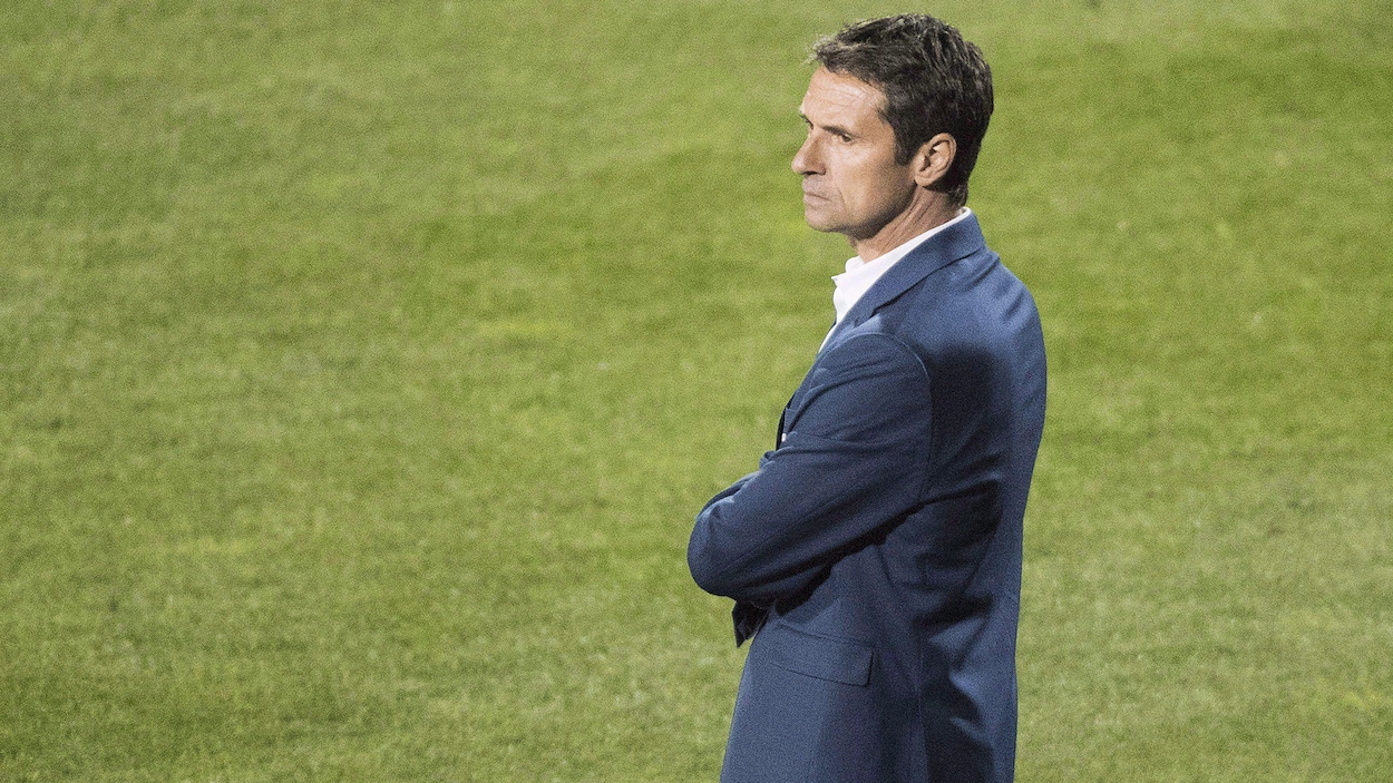 Il observe ses joueurs pendant un match.