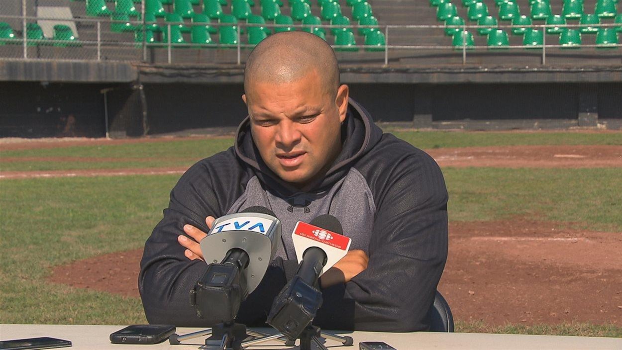 Il donne une conférence de presse sur un terrain de baseball.