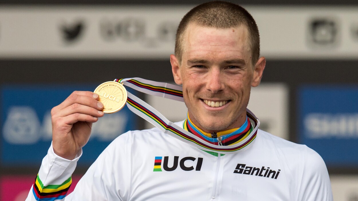 Tout sourire, il montre fièrement sa médaille.