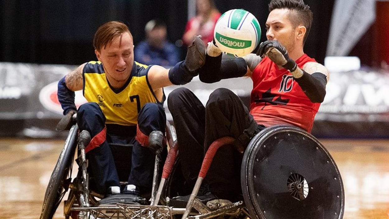 Un joueur de l'équipe canadienne manipule le ballon devant un défenseur de l'équipe adverse.