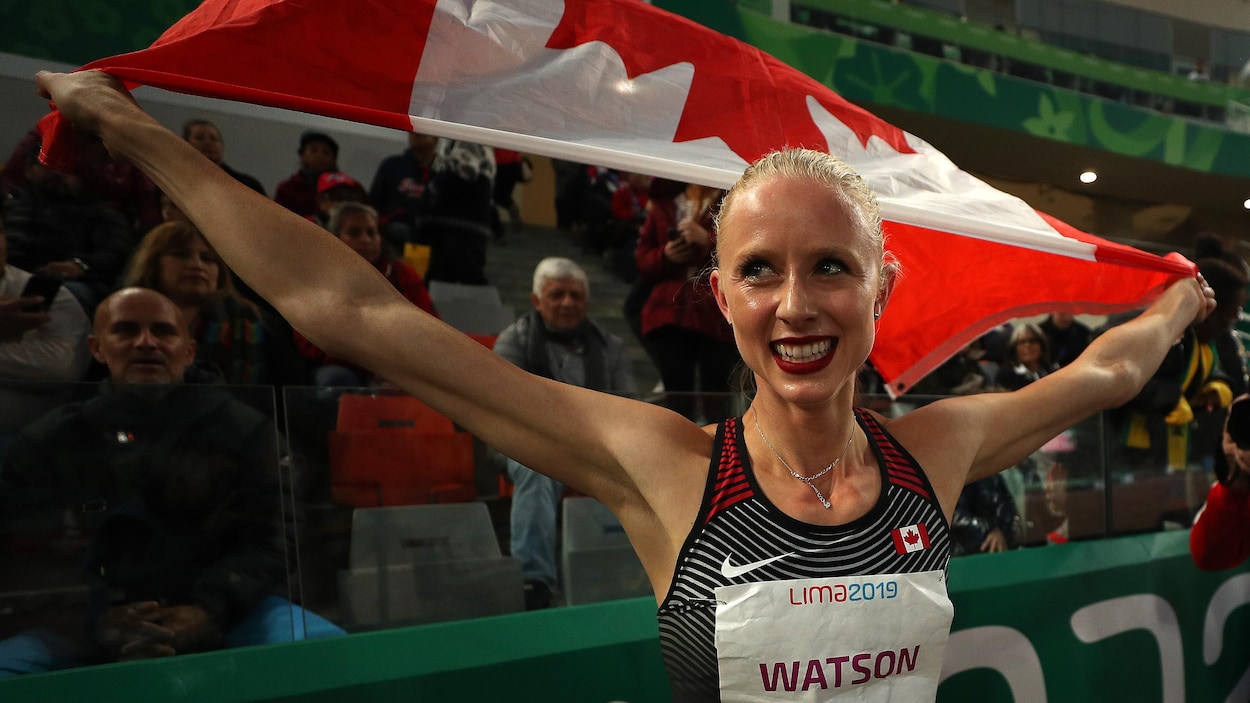 Il tient le drapeau canadien derrière son dos.