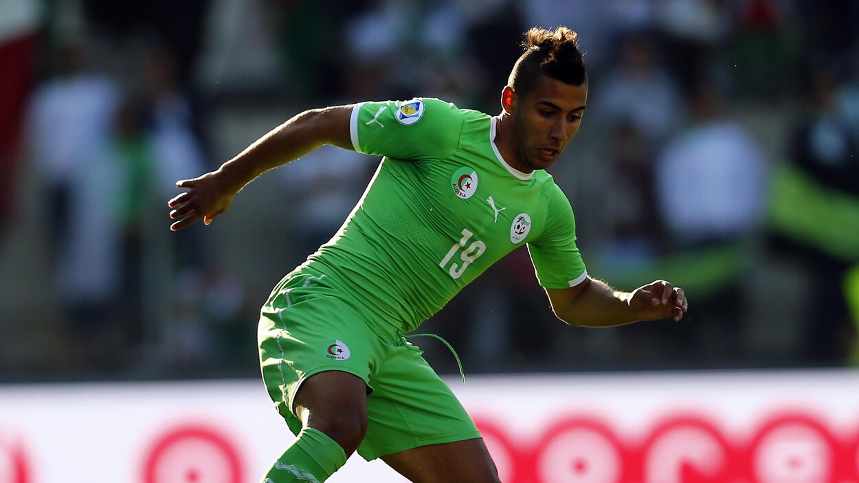 Dans les couleurs de l'Algérie, Saphir Taider contrôle le ballon pendant un match de la Coupe du monde 2014, au Brésil. Dans les couleurs de l'Algérie, Saphir Taider contrôle le ballon pendant un match de la Coupe du monde 2014, au Brésil.