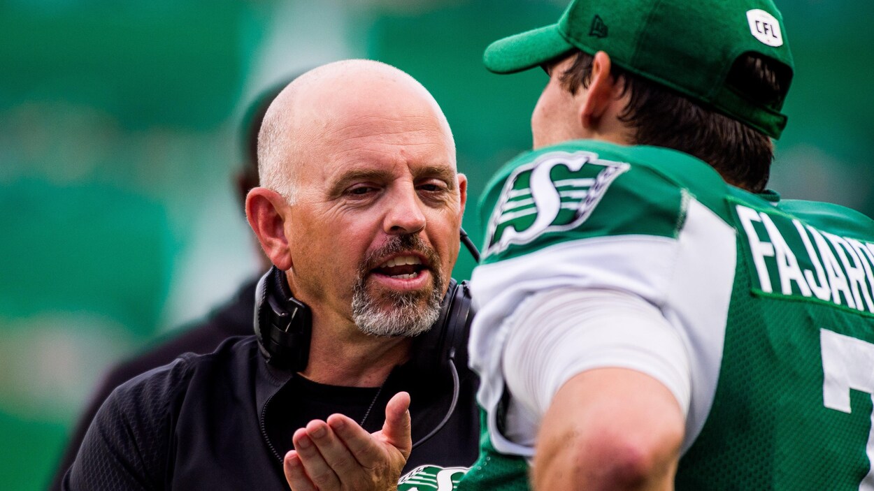 L'entraîneur-chef Craig Dickenson en conversation avec son quart-arrière Cody Fajardo.
