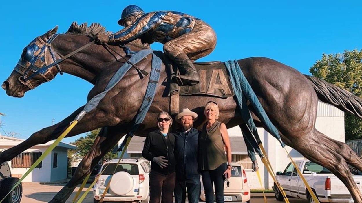 La sculptrice Jocelyn Russell, à droite, avec deux de ses collaborateurs, Alex Emmons, à gauche, et Karl Schmidt, au centre, devant le monument.