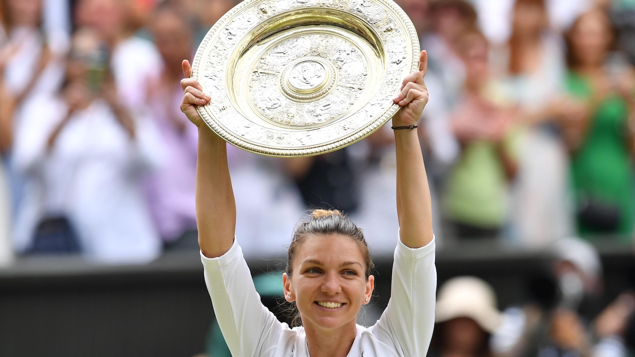 Elle soulève le trophée.