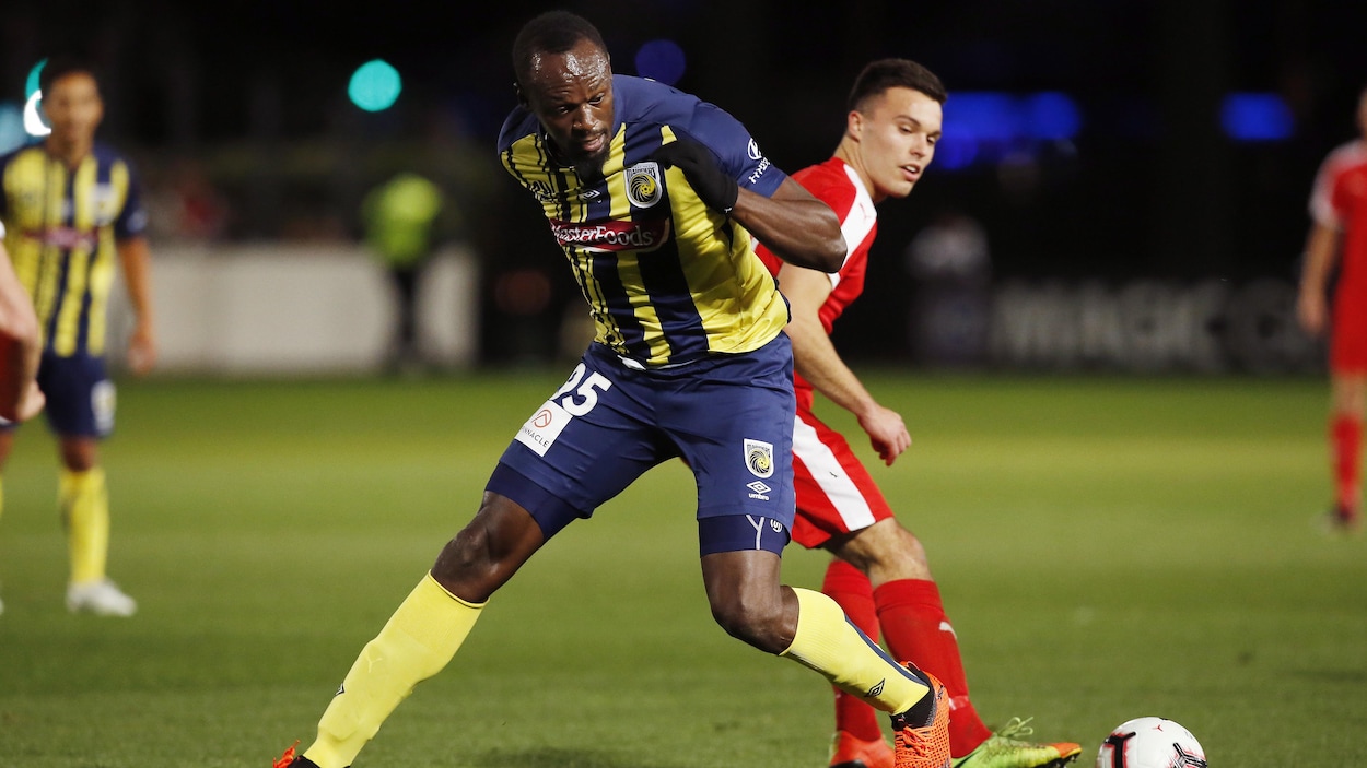 Usain Bolt (à l'avant) tente de maîtriser le ballon au cours de son premier match.