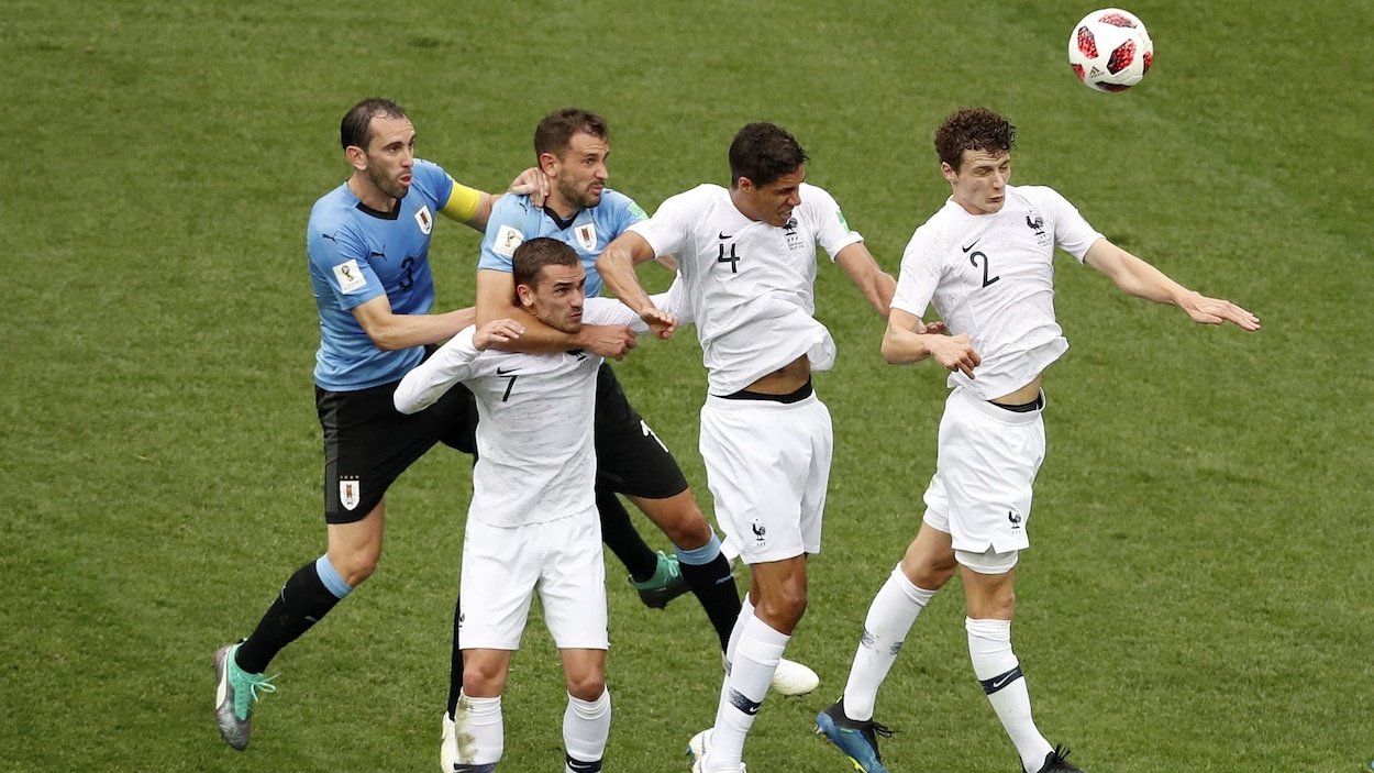 Des joueurs uruguayens (en bleu) et français (en blanc) se disputent un ballon au cours du match des quarts de finale du Mondial de 2018 entre les deux équipes.