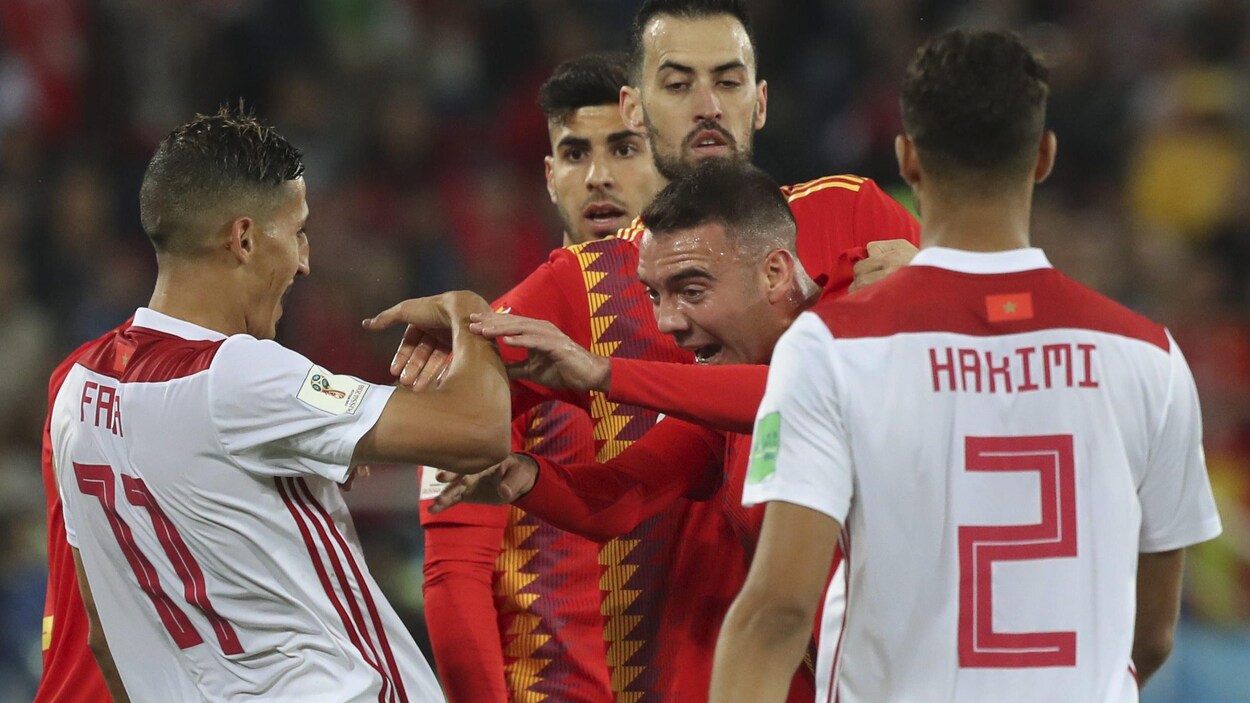 L'Espagnol Iago Aspas (au centre) se dispute avec le Marocain Faycal Fajr (à gauche) au cours de leur match du groupe B de la Coupe du monde de soccer.