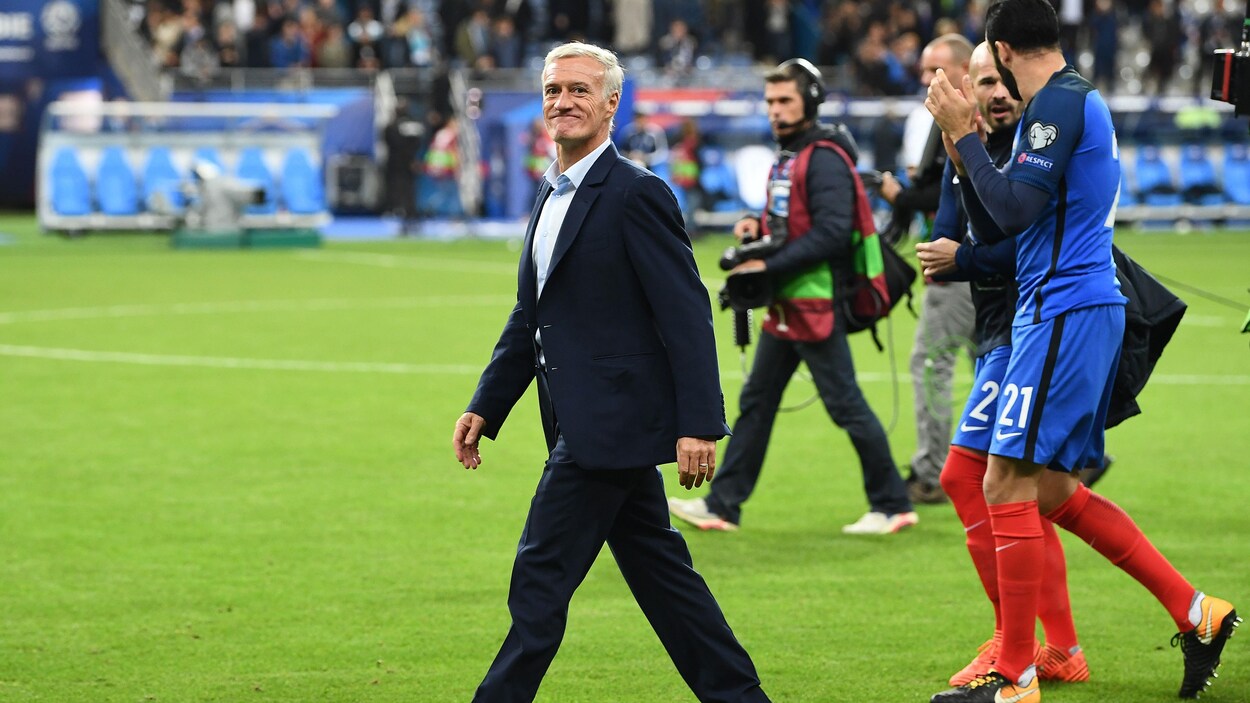Il marche sur un terrain de soccer.