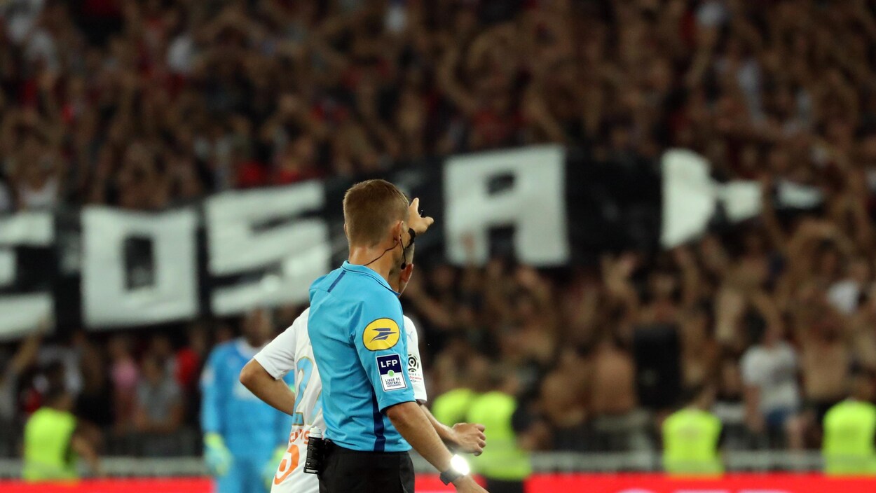 Il signale l'interruption du match.