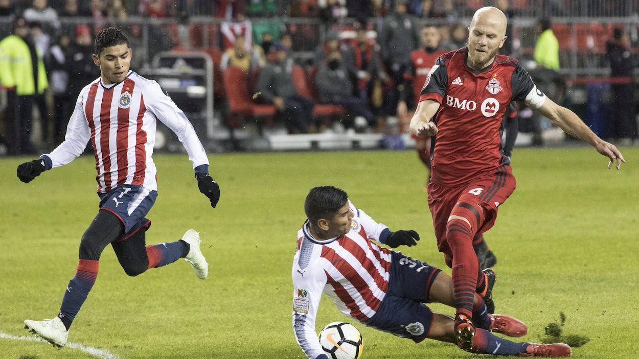 Carlos Salcido (au centre), de Chivas de Guadalajara, tacle Michael Bradley (à droite), du Toronto FC. Carlos Salcido (au centre), de Chivas de Guadalajara, tacle Michael Bradley (à droite), du Toronto FC.