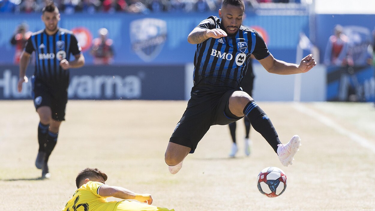 Il saute par-dessus Hector Jimenez du Crew de Columbus.