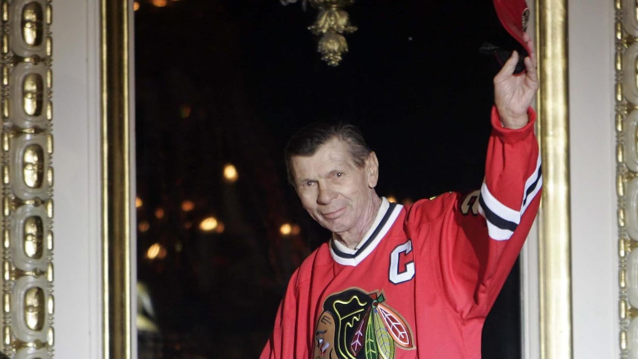 Stan Mikita avec un chandail des Blackhawks salue la foule de la main