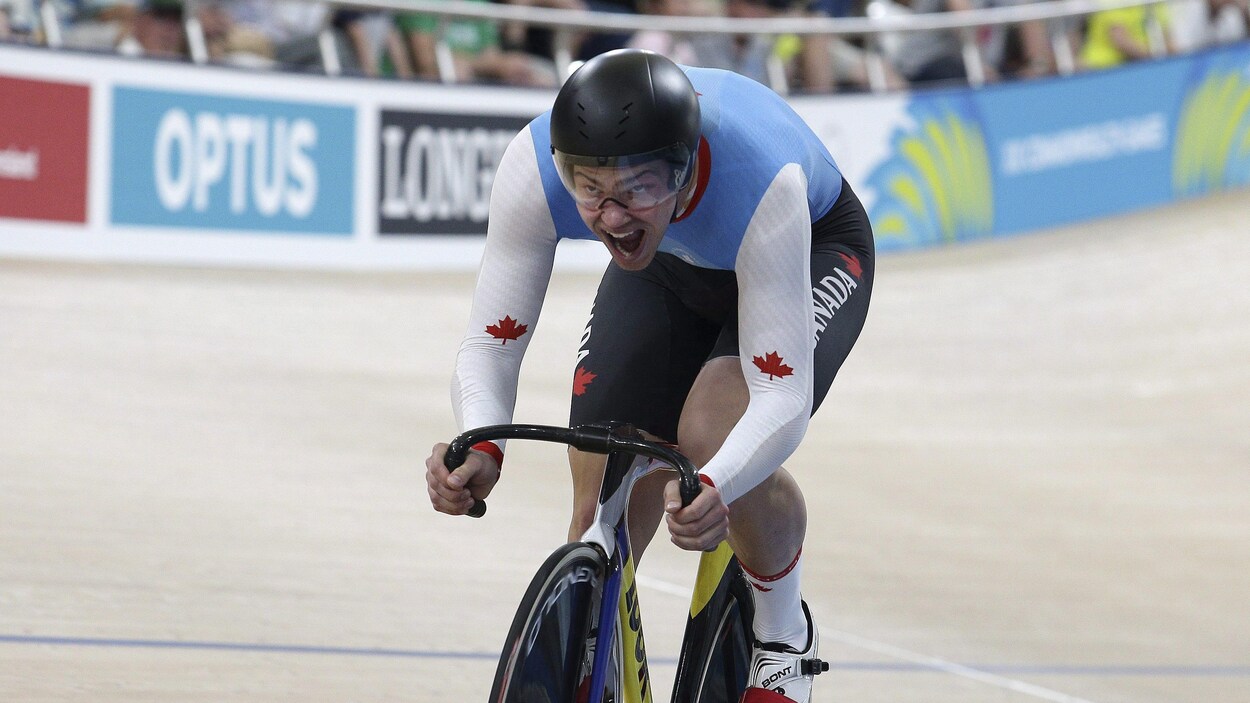Il pédale sur une piste de cyclisme intérieure.