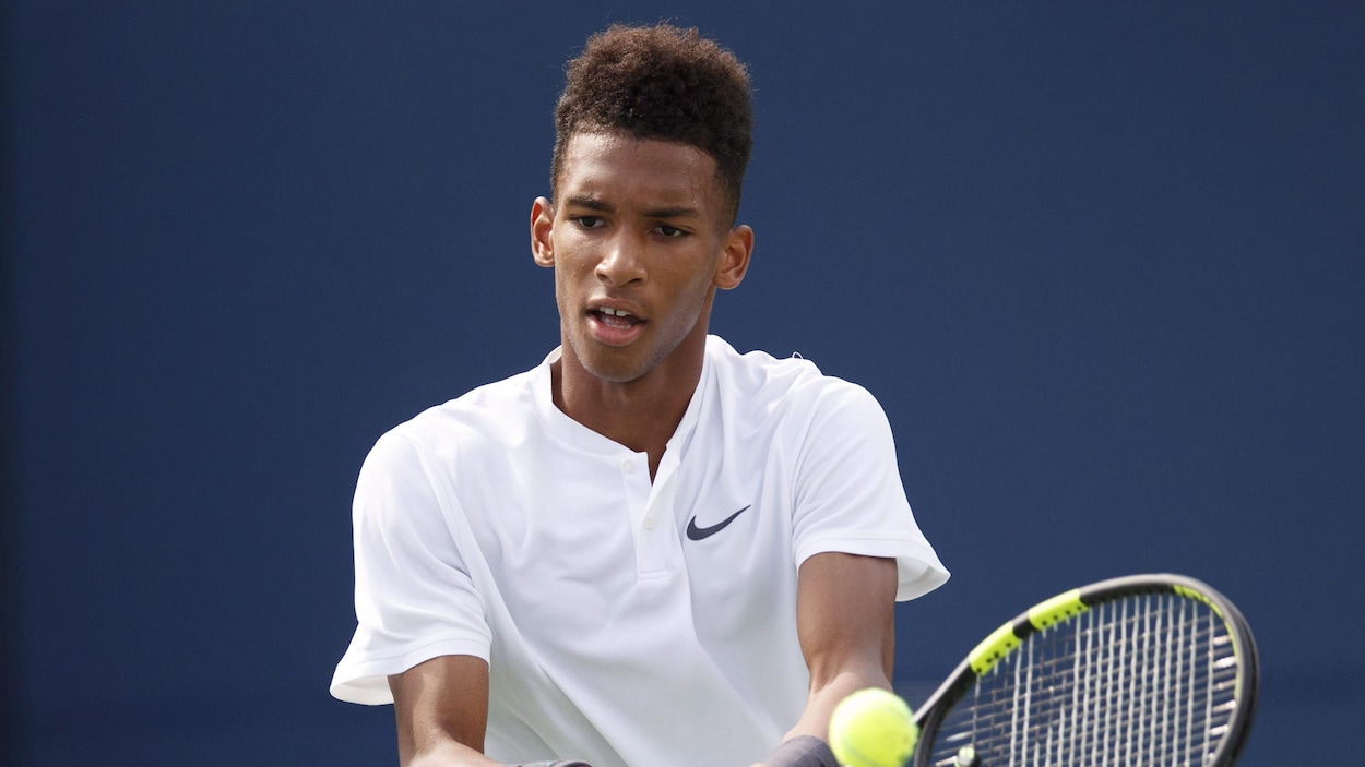 Felix Auger-Aliassime frappe la balle en retour de service. Felix Auger-Aliassime frappe la balle en retour de service.