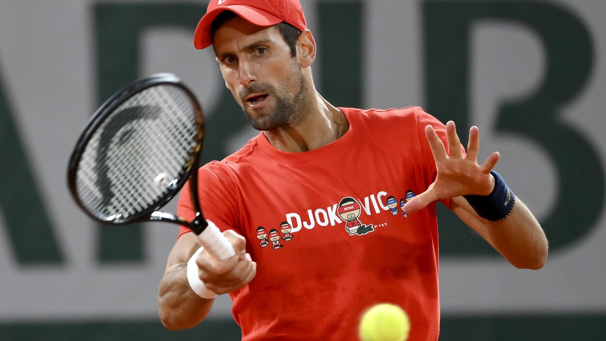 Un joueur de tennis frappe une balle.