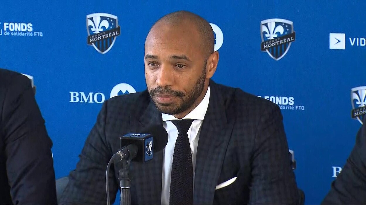 Un homme en complet en conférence de presse