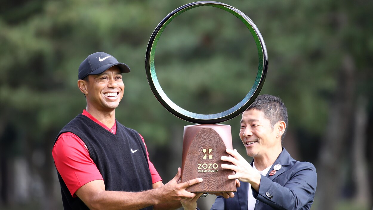 Deux hommes tiennent un trophée.
