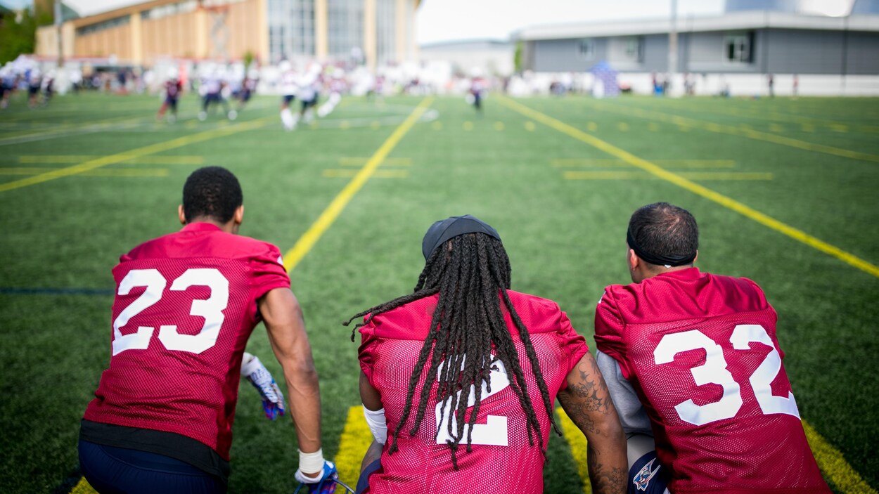 Tommie Campbell, Dominique Ellis et Mitchell White sont agenouillés sur le côté du terrain. Tommie Campbell, Dominique Ellis et Mitchell White sont agenouillés sur le côté du terrain.
