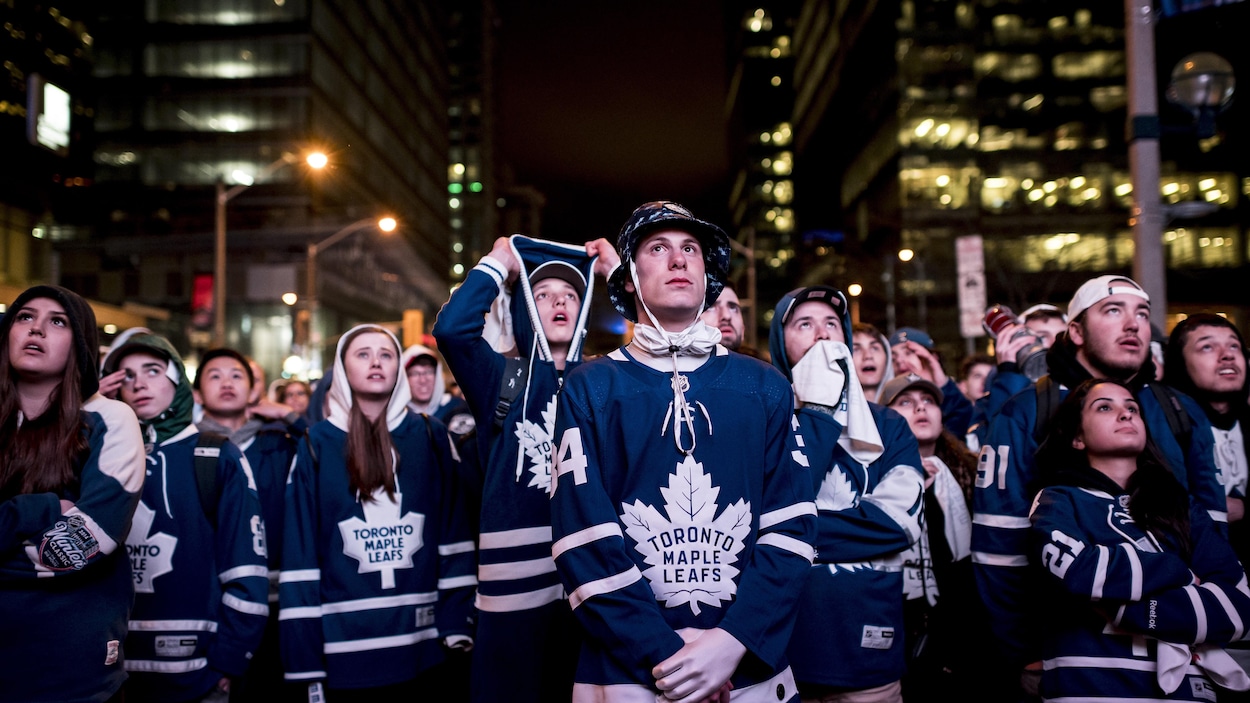Une foule de partisans des Maple Leafs regardent l'écran géant à l'extérieur de l'aréna Banque Scotia, à Toronto.