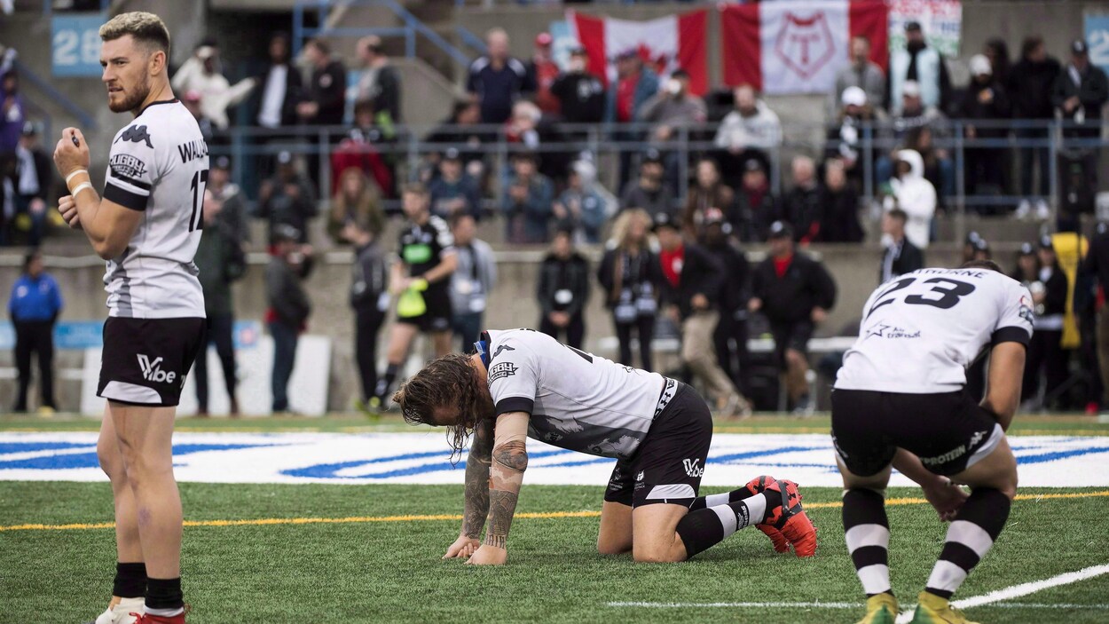 Des joueurs de rugby réagissent à une défaite au coup de sifflet final.