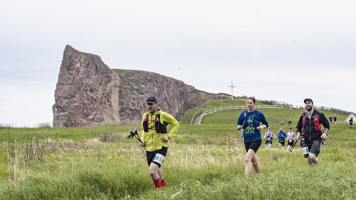 Des participants courent devant le Rocher Percé en juin 2019.