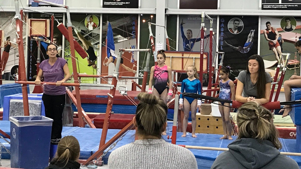 Une entraîneuse parle à des jeunes dans un cours de gymnastique.