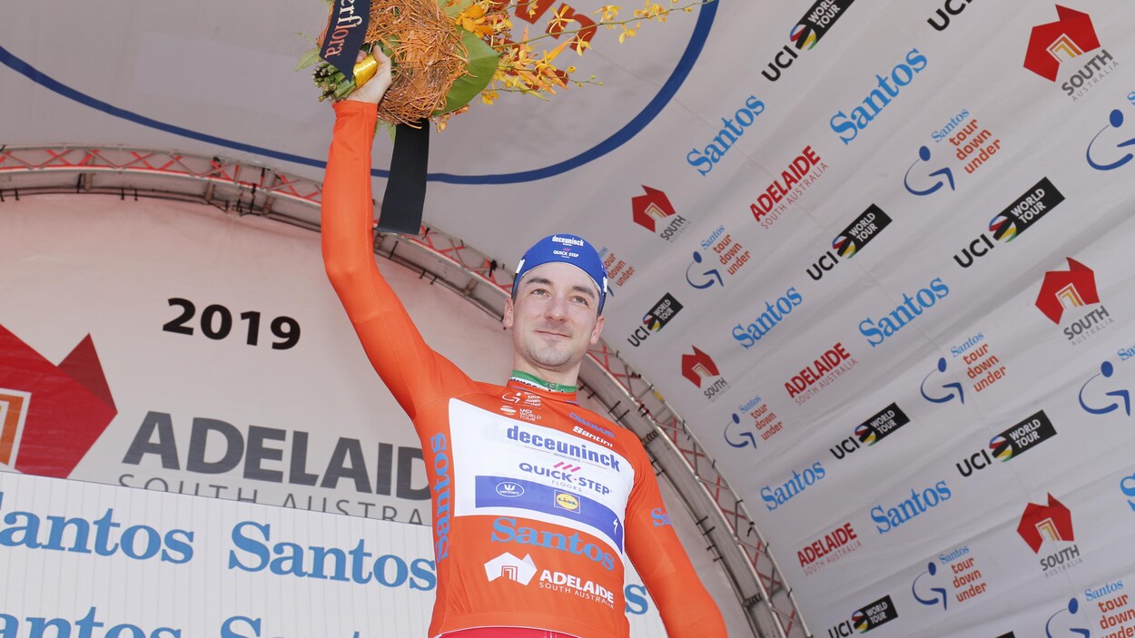 Il salue la foule, bouquet de fleurs à la main droite, au terme d'une première journée couronnée de succès au Tour Down Under.