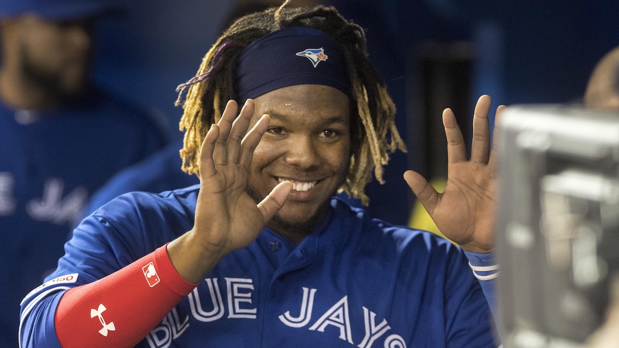 Un joueur de baseball tend les bras pour célébrer avec l'un de ses coéquipiers.
