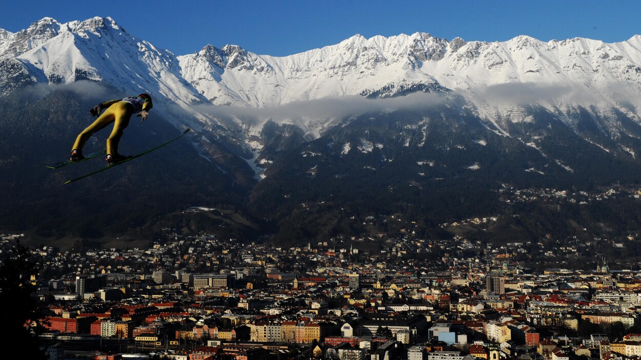 Un sauteur à ski plane au-dessus de la ville d'Innsbruck, en Autriche. Un sauteur à ski plane au-dessus de la ville d'Innsbruck, en Autriche.
