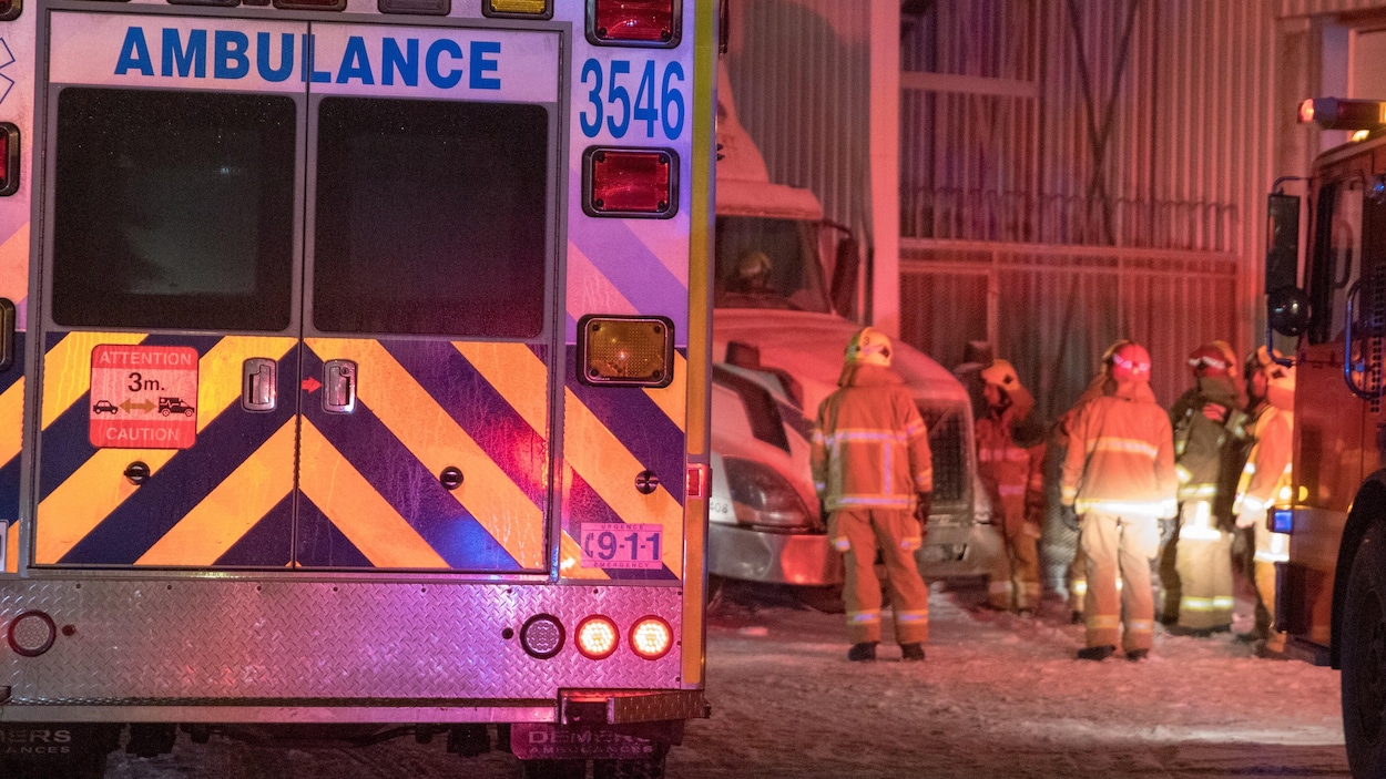 Des pompiers sont près du camion.