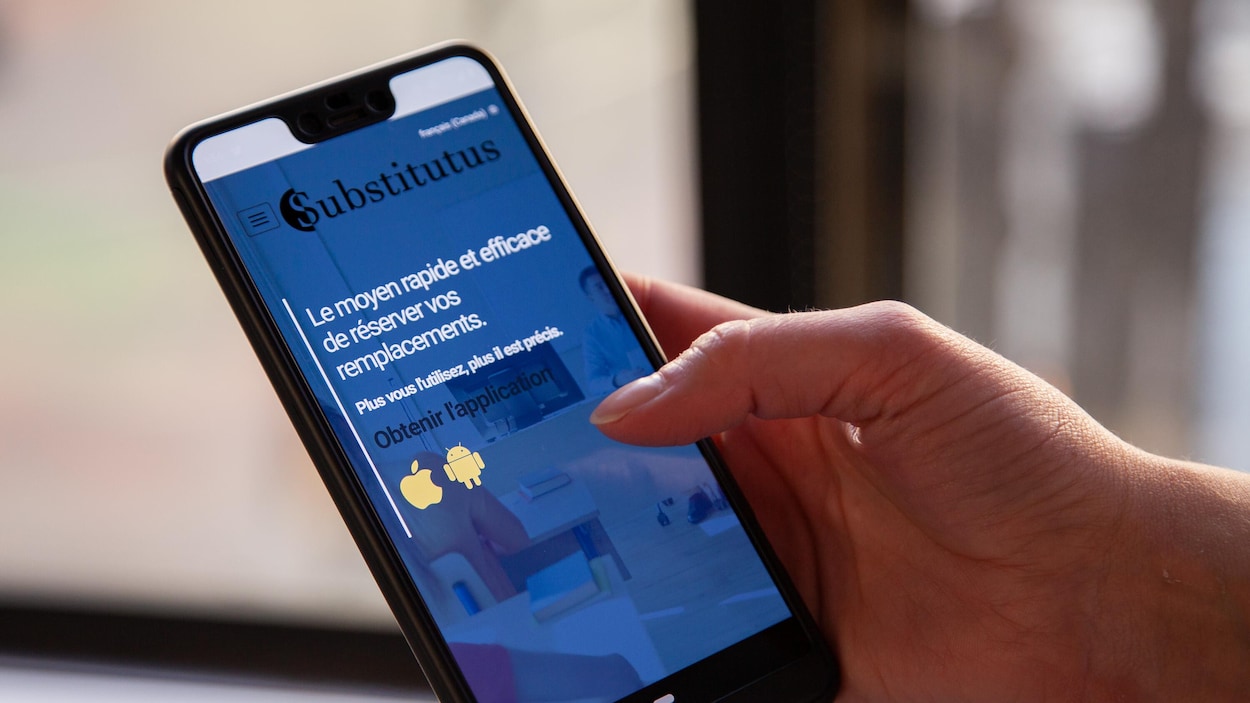 Une femme tient un appareil mobile dans ses mains. L'application est ouverte sur le téléphone et l'on peut y apercevoir le logo de Subsittutus ainsi que « Le moyen rapide et efficace de réserver vos remplacements.»
