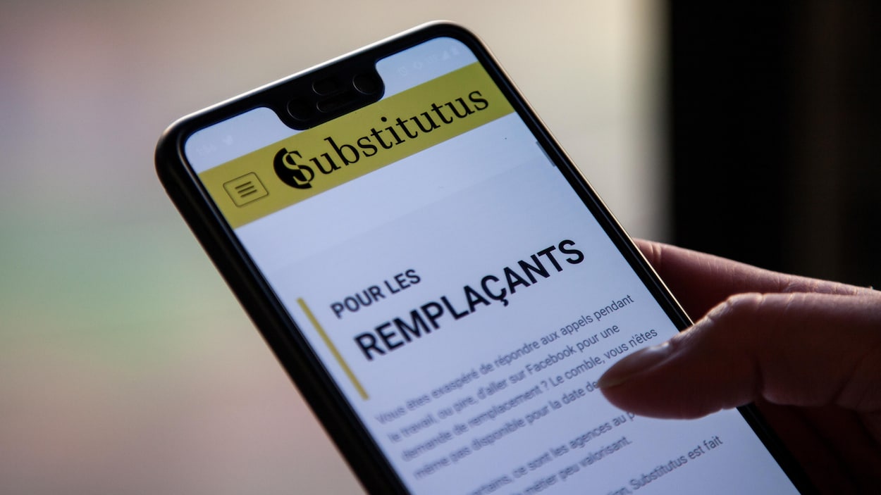 Une femme tient un cellulaire sur lequel s'affiche une page de l'application mobile de Substitutus où il est écrit : « Pour les remplaçants ».